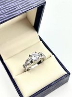 Ring in presentation box showing center crystal and side accents