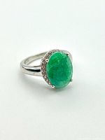 Front view of sterling silver ring showing emerald and halo