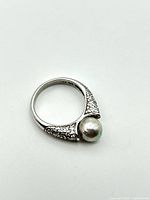 Ring showing pearl and pavé shoulders