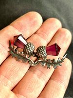 Front view showing twin thistle design and purple glass stones