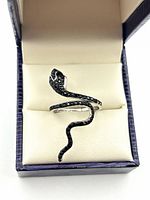 Ring in presentation box showcasing snake form and pavé stones
