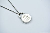 Close-up of front of sterling padlock pendant on chain showing 925, T&Co, 1837 marks