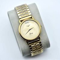 Front view of gold plated Longines watch on cushion showing dial, bracelet and overall style