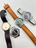 Group shot of all four watches showing fronts and straps