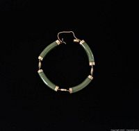 Full view of bracelet in circular form showing all jade segments and gold links