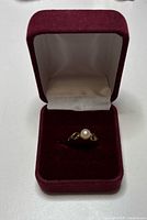 Ring in burgundy presentation box, pearl facing front
