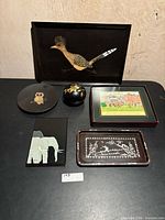 Group shot of six Couroc lacquer pieces displayed on table