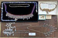 Overview of lot showing beaded bib, slim bead strand, faience set, and silver necklaces