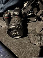 D80 body with 18-55mm lens, strap and cap visible