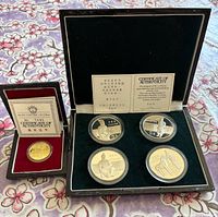 Gold coin in red case, certificates visible
