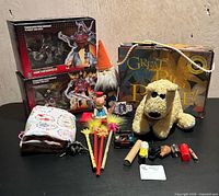 Overview showing all items: two boxed Transformers, puzzle box, plush dog, gnome, feather wands, wooden peg toy, cloth bag, small accessories
