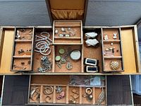 Open jewelry box displaying all compartments and jewelry contents