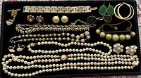 Overview of entire jewelry assortment arranged on black tray