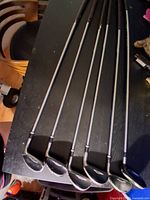 Six Cleveland Hi Bore XLi women's golf clubs laid out on a table, showing graphite shafts and club heads from #5 iron to hybrid.