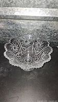 Top and angled views of a large clear glass bowl showing the starburst cut pattern and scalloped rim.