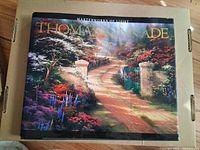 Front cover of the art book 'Masterworks of Light' by Thomas Kinkade showing a garden path scene with flowers and greenery.
