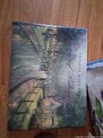 Book front with illustrated dust jacket showing village scene at night with street lamps and houses.