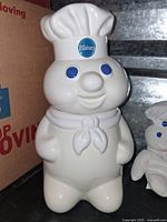 Front view of Pillsbury Doughboy cookie jar showing white ceramic figure with blue eyes and Pillsbury logo on chef hat.