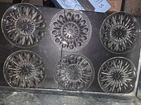 Top view of six clear crystal salad plates arranged in two rows of three, showing their starburst and circular motifs design