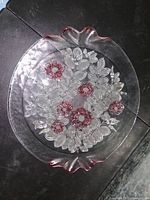 Full view of the vintage glass plate showing detailed raised leaf pattern and painted pink flowers with slight wear on the paint.