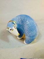 Front angled view showing the polar bear's blue textured body and gold detailing on the face.