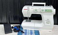 Front view of Janome 2212 sewing machine with foot pedal and power cord
