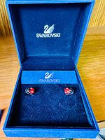 Blue Swarovski box open showing the pair of ladybug earrings inside.