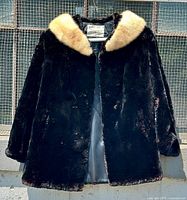 Full photograph of vintage women's black sheared beaver fur coat with contrasting light and dark brown mink fur collar.