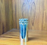 Front view of vintage silver-plated brutalist vase on wooden surface, showing full profile and distinctive textured rim design.