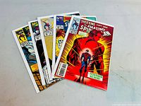 Five vintage Amazing Spider-Man comic books displayed fanned out, showing colorful covers and good condition.