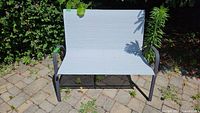 Front view of metal frame bench with light gray sling fabric seat and back