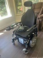Full view of wheelchair front left with charger on seat