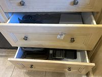 Two drawers showing mitts in upper and nested baking pans in lower