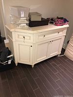 Front view of cream wood sideboard showing drawers, doors, top surface