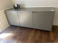 Front view of grey laminate sideboard with three doors