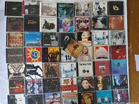 Overview of the 50 rock CDs from the 1990s, arranged in rows showing cover artwork and jewel cases