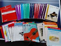 Photo showing a variety of music instruction books arranged in rows, mostly piano technique and study books with some guitar books visible