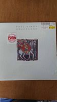 Front cover of Paul Simon Graceland vinyl record showing artwork and DMM sticker.