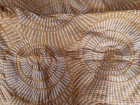 Close-up image showing the detailed circular spiral quilting pattern of the harvest yellow duvet cover.