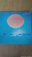 Front cover of the Santana Caravanserai vinyl record album showing desert caravan with large sun/moon in background in blue and pink tones.