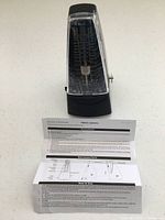 Front view of metronome with instruction sheet displayed