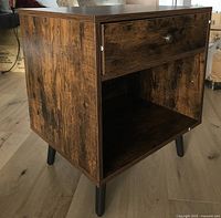 Angled view of entire nightstand showing drawer, shelf, legs