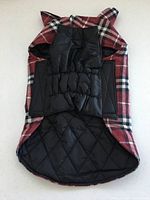 Full view of dog coat interior showing black quilted lining and elasticized belly panel