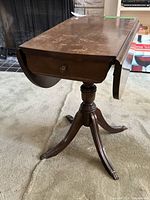 Full view of drop-leaf side table with one leaf down