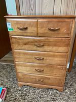 Full front view of wooden five-drawer dresser
