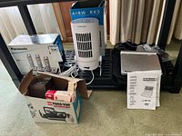 Group shot showing boxed Panasonic phone system, pillar fan, Mintek DVD player with manual, Panavue slide viewer box