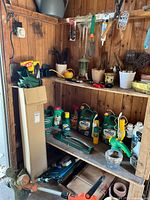 Overall view of shed shelves with trimmer, chemicals, hand tools, extension cord