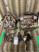 Overview of both chalet cuckoo clocks with accessories displayed