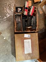 Open box showing train cars, track, transformer and outer box