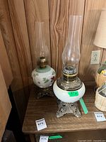 Both milk glass oil lamps on table